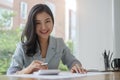 Young asian business woman sitting at her workplace and reading financial document Royalty Free Stock Photo