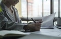 Young asian business woman sitting at her workplace and reading financial document Royalty Free Stock Photo