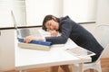 Young Asian business woman lying down on the desk in office because tired overworked. Royalty Free Stock Photo
