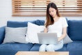 Young asian business woman smile and work from home with laptop computer online to internet on sofa. Royalty Free Stock Photo