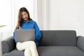 Young asian business woman work from home with laptop computer online to internet on sofa, freelance girl using notebook Royalty Free Stock Photo