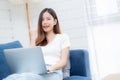 Young asian business woman smile and work from home with laptop computer online to internet on sofa. Royalty Free Stock Photo