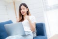 Young asian business woman smile and work from home with laptop computer online to internet on sofa. Royalty Free Stock Photo