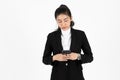 Young Asian business woman in suit holding mobile smart phone over white isolated background Royalty Free Stock Photo