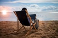 Asian business woman with tablet computer during tropical beach vacation. Freelancer working on laptop lying on sun lounger. Royalty Free Stock Photo