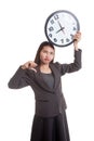 Young Asian business woman thumbs down with a clock. Royalty Free Stock Photo