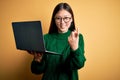 Young asian business woman wearing glasses and working using computer laptop Beckoning come here gesture with hand inviting Royalty Free Stock Photo