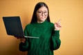 Young asian business woman wearing glasses and working using computer laptop Pointing aside worried and nervous with forefinger, Royalty Free Stock Photo