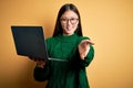 Young asian business woman wearing glasses and working using computer laptop smiling cheerful offering palm hand giving assistance Royalty Free Stock Photo