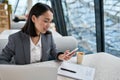 Young Asian business woman wearing suit working in office using cell phone. Royalty Free Stock Photo