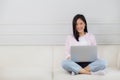 Young asian business woman work from home with laptop computer online to internet on sofa in living room. Royalty Free Stock Photo