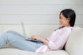 Young asian business woman work from home with laptop computer online to internet on sofa in living room. Royalty Free Stock Photo
