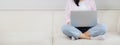 Young asian business woman work from home with laptop computer online to internet on sofa in living room. Royalty Free Stock Photo