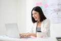 Young asian business woman working on computer laptop in office room with paperwork document Royalty Free Stock Photo