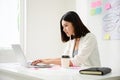 Young asian business woman working on computer laptop in office room with paperwork document Royalty Free Stock Photo