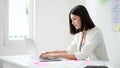 Young asian business woman working on computer laptop in office room with paperwork document Royalty Free Stock Photo