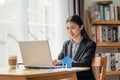 Young Asian business woman working in the office and using her laptop in her office with paper house Royalty Free Stock Photo