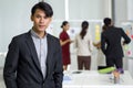 Young asian businessman in black suit stands in his pocket with a confident expression. The team is preparing for the meeting in Royalty Free Stock Photo