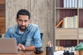 Young Asian businessman in casual clothes stitting and replying an e-mail. Handsome 30s man working at home, looking to camera Royalty Free Stock Photo