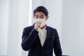 Young smart Asian businessman is cough and wearing a mask at workplace to prevent the corona virus outbreak