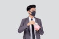 Young asian businessman in face mask holding money dollar and piggy bank isolated on white background. Royalty Free Stock Photo