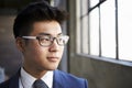 Young Asian businessman looking out of window, close up Royalty Free Stock Photo