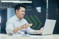 Young Asian businessman looking surprised at laptop and credit card in hand. Sitting in the office Royalty Free Stock Photo