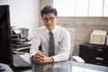 Young Asian businessman at an office desk, looking to camera Royalty Free Stock Photo