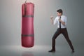 Young asian businessman punching boxing bag Royalty Free Stock Photo