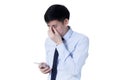 Young Asian businessman rubbing his tired eyes from long hours of works using smart phone Royalty Free Stock Photo