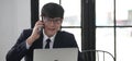 Young asian businessman sitting in business first class seat inside airplane via using smartphone