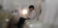 Young asian businessman sitting in business first class seat inside airplane via using smartphone