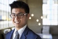 Young Asian businessman smiling to camera, head and shoulders