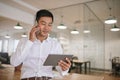 Asian businessman discussing work on his cellphone in an office Royalty Free Stock Photo