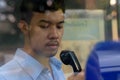 Young Asian businessman using the payphone outdoors Royalty Free Stock Photo