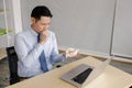 Young asian businessman video call consult doctor after he coughs and vomits something on his hand suspected to be gastro-