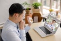 Young asian businessman video call consult doctor after he coughs and vomits something on his hand suspected to be gastro-