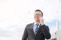 Businessman wearing black suit smiling while talking via mobile phone Royalty Free Stock Photo