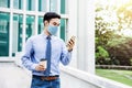 Young Asian Businessman Wearing a Surgical Mask and Using a Smart Phone in City. Healthcare in New Normal Lifestyle Royalty Free Stock Photo