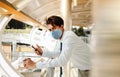 Young Asian Businessman Wearing a Surgical Mask and Using a Smart Phone in City. Healthcare in New Normal Lifestyle Concept. Royalty Free Stock Photo