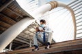 Young Asian Businessman Wearing a Surgical Mask and Using a Smart Phone in City. sitting on Staircase. Healthcare in New Normal Royalty Free Stock Photo