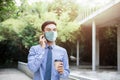 Young Asian Businessman Wearing a Surgical Mask and Using a Smart Phone. Healthcare in New Normal Lifestyle Royalty Free Stock Photo