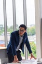 Young Asian businessman wears glasses to touch his desk in a comfortable