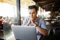 Young asian businessman working with laptop computer and notebook in cafe casual entrepreneur. Freelance work