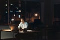 Young Asian businessman working overtime in a dark office Royalty Free Stock Photo