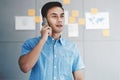 Young Asian Businessman Working in Office Meeting Room and Talking via Smartphone. Document`s Data Plans and Project as backgroun