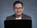 Young Businessman Working on His Laptop, Smiling Expression