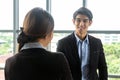 Young Asian Businessperson are standing and talking about financial business concept to agree on trade proposals within the modern Royalty Free Stock Photo