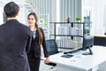 Young Asian Businessperson are standing and talking about financial business concept to agree on trade proposals within the modern Royalty Free Stock Photo