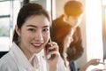 Young asian businesswoman beautiful charming smiling and talking on the mobile phone in meeting room Royalty Free Stock Photo